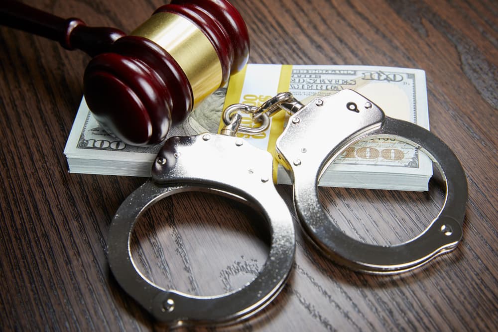 DUI fine, a gavel, and handcuffs arranged on a wooden surface.
