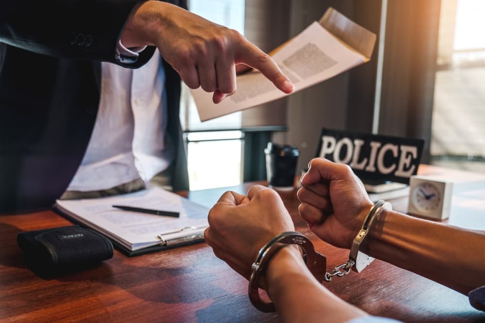 Law enforcement officer interrogating Criminals male with handcuffs in the investigation room Police officer interviewing after committed a marijuana crime