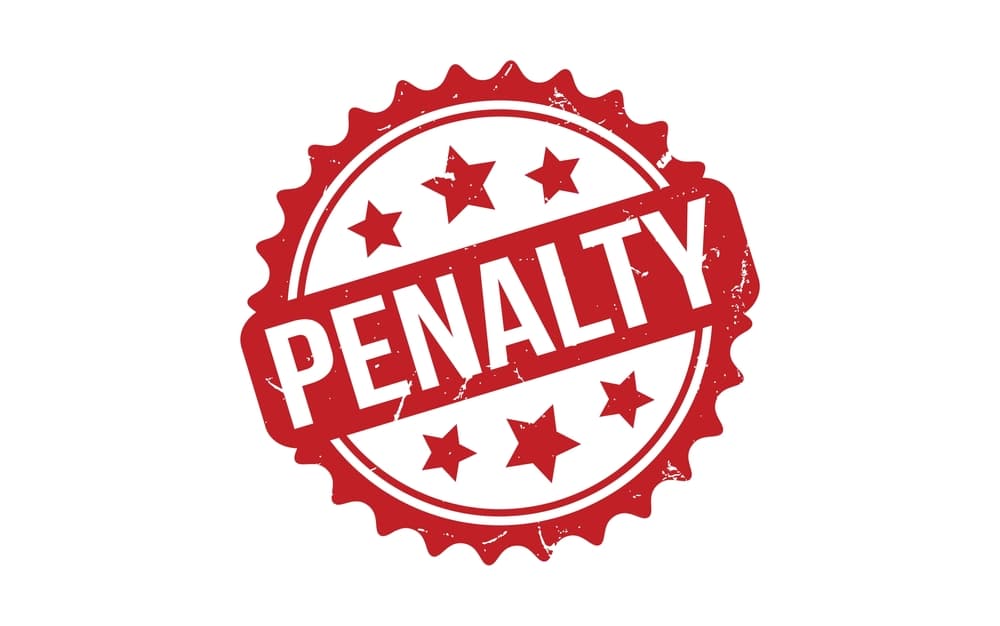 Red rubber grunge stamp with the word 'Penalty' stamped in bold letters, symbolizing legal or financial penalties.