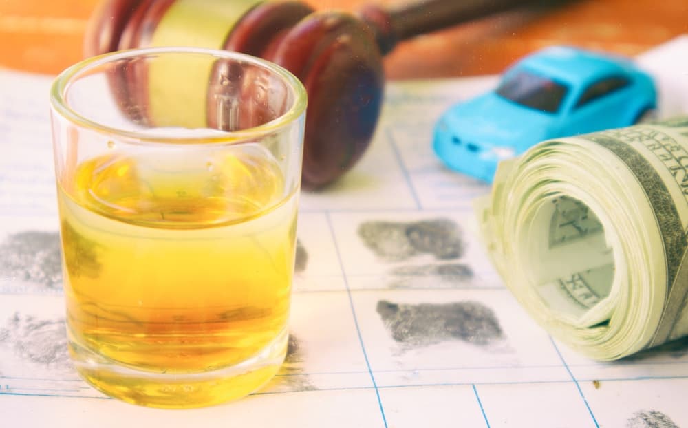 Drunk driving concept: A glass of whiskey sits on a fingerprint background, symbolizing the intersection of alcohol consumption and crime.






