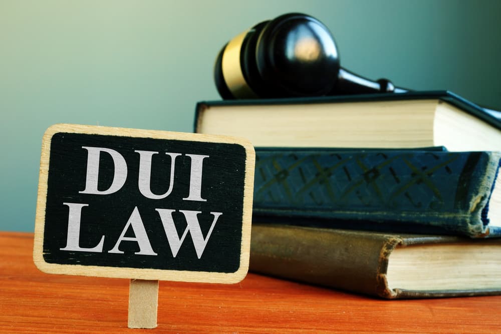 DUI law concept with traffic sign and legal books, symbolizing legal consequences of driving under the influence.