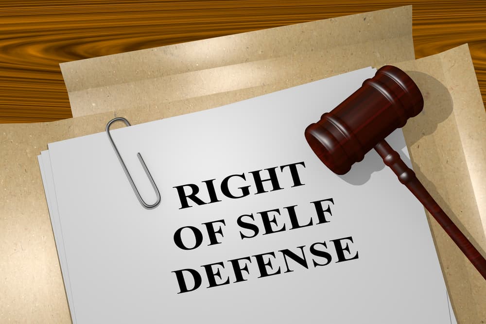 Create a three-dimensional illustration depicting the title "RIGHT OF SELF DEFENSE" on legal documents, symbolizing the legal concept.