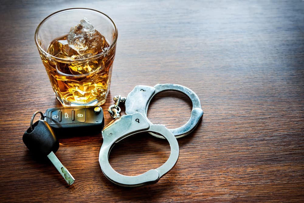 Whiskey with car keys and handcuffs: a concept for drinking and driving.






