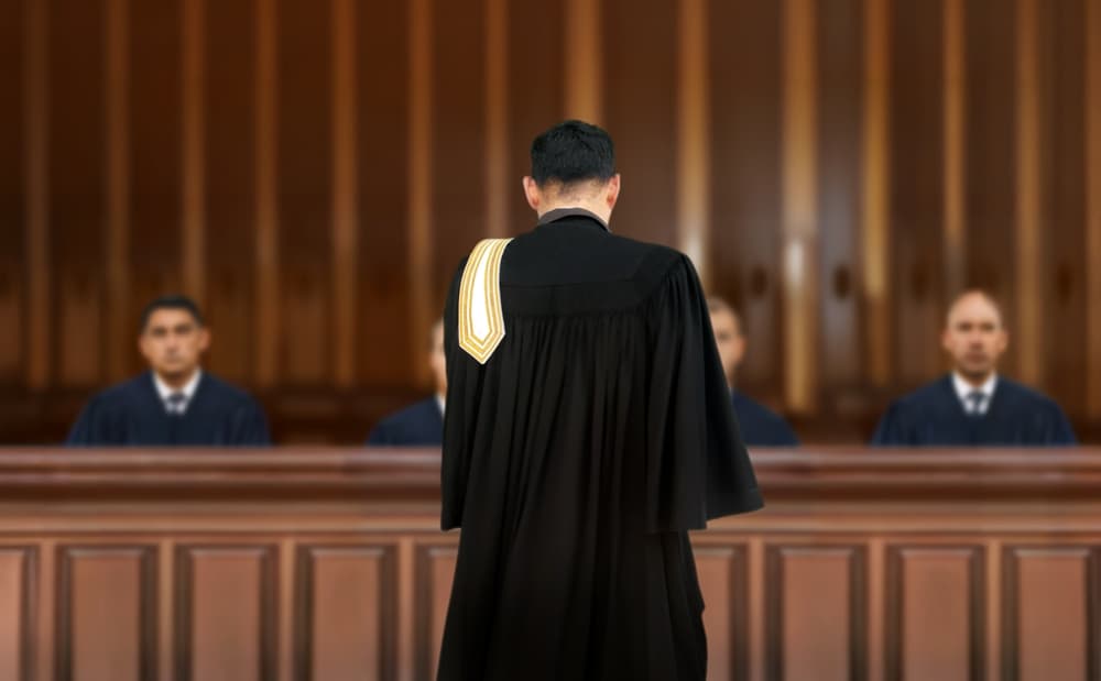 A lawyer addressing the jury in a courtroom, symbolizing the concepts of justice and law during a trial.