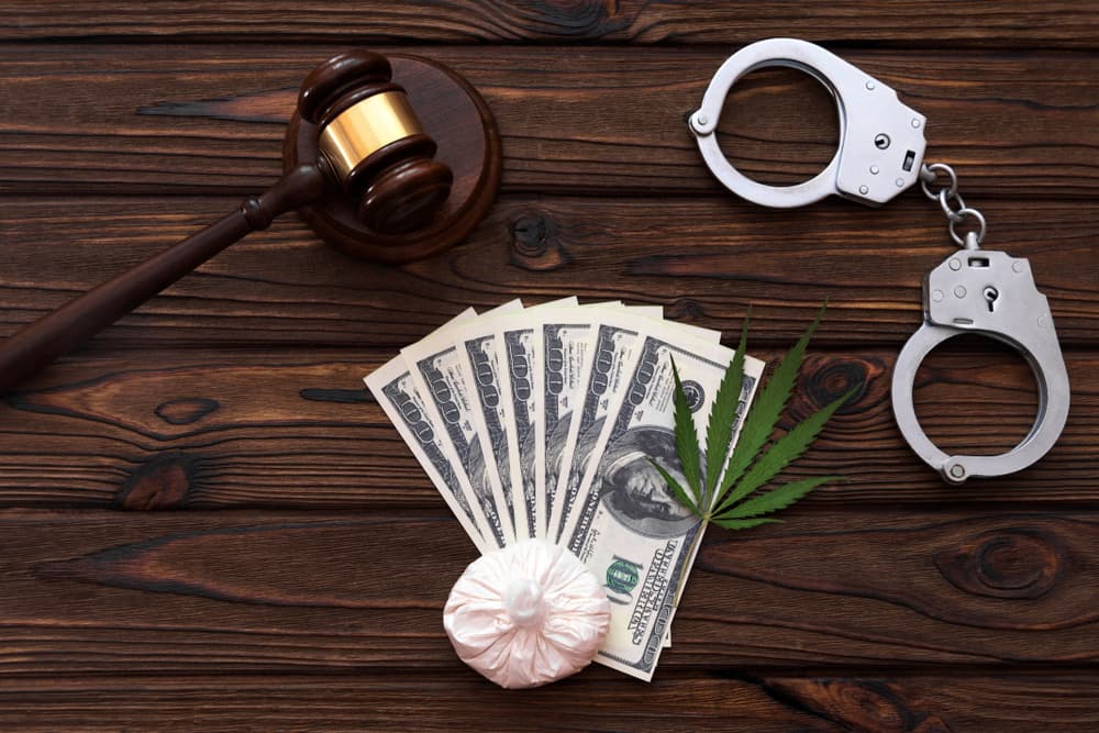 Judge's hammer, American dollar bills, drugs, handcuffs on wooden background