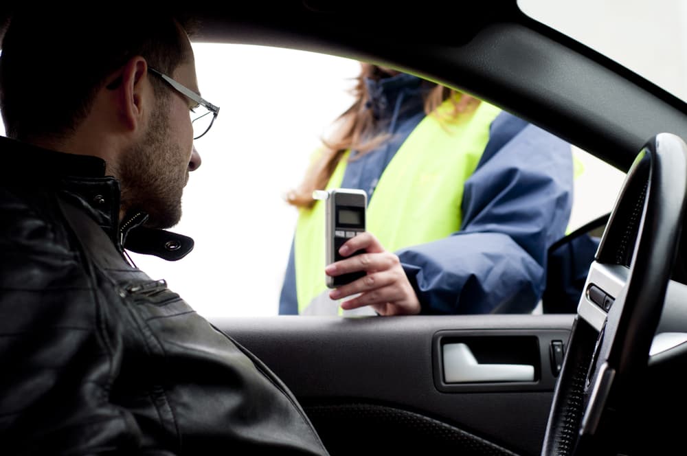 Inside-the-car view of a young driver who crashed after refusing a breath test, facing serious legal and license penalties.