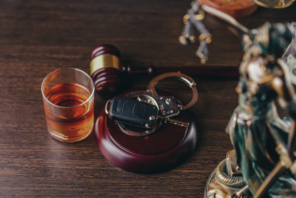 Whiskey, car keys, and handcuffs symbolizing DUI charges—challenging evidence like faulty tests or illegal stops can aid defense.