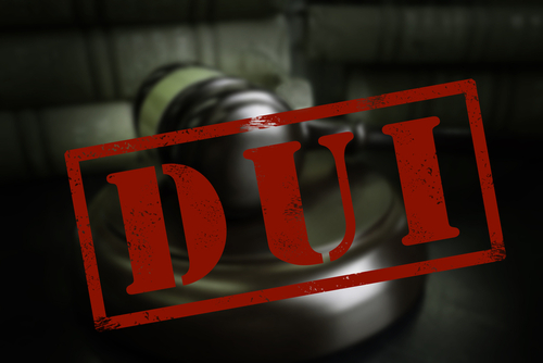 Close-up of a judge's gavel with the word "DUI" stamped in bold red letters across the image.