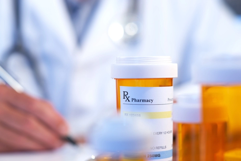 Prescription medication bottle and pills displayed on a table, illustrating the differences between marijuana DUI and prescription drug DUI charges under California law.