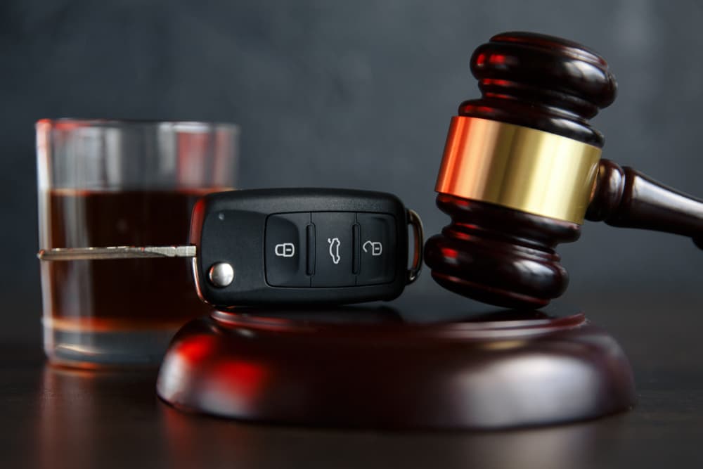 Glass of alcohol, car keys, and a gavel displayed together, illustrating Chudnovsky Law's commitment to protecting the rights of first DUI clients throughout their case.