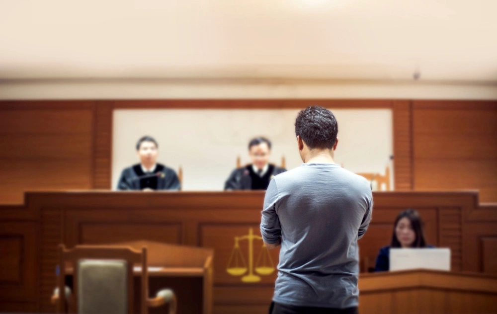 Person standing before judges in a courtroom, illustrating the value of experienced legal defense at the Foltz Criminal Justice Center for California Penal Code § 261.5 cases.