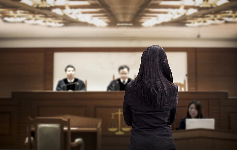 Person standing before judges in a courtroom, illustrating the potential penalties for petty theft charges under California Penal Code §§ 484 and 459.5 in Los Angeles.